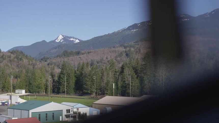 Small airport surrounded by forests with mountains in the background