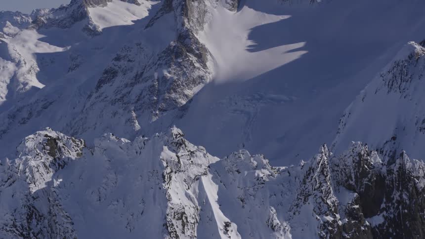 Snow covered mountain peaks and ridges under bright daylight