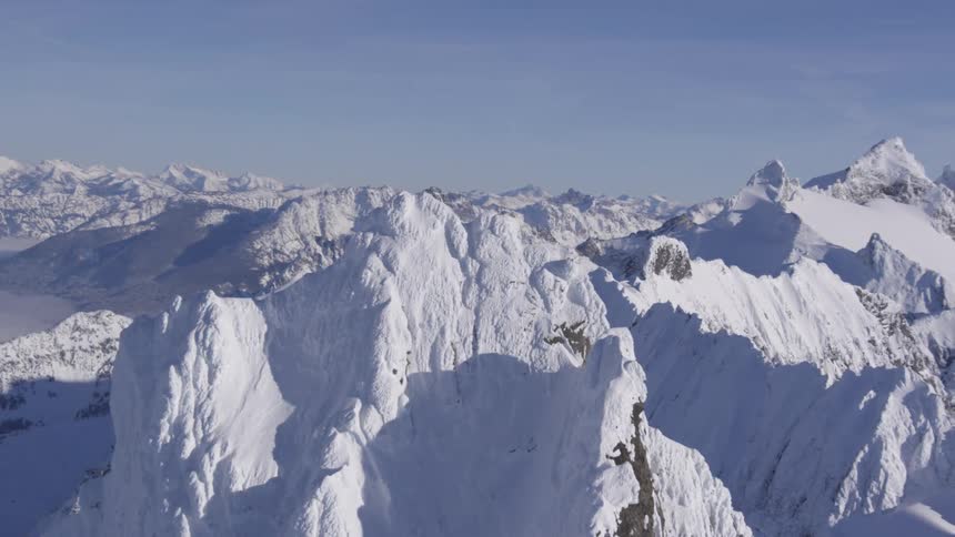 A range of snowcapped mountains on a blue sky day