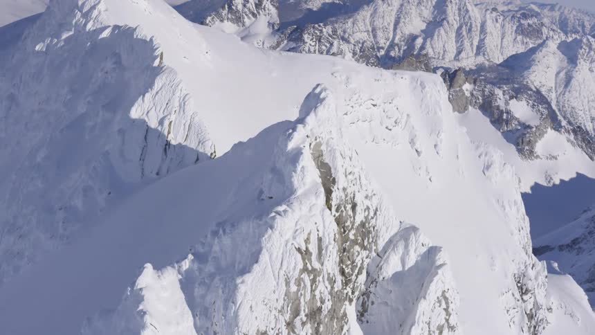 Snowcovered mountains with steep peaks under bright sunlight