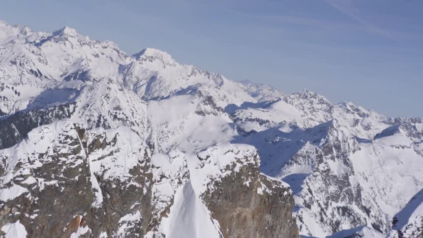 Rough terrain snow covered mountain ridge and snow covered mountains across the landscape