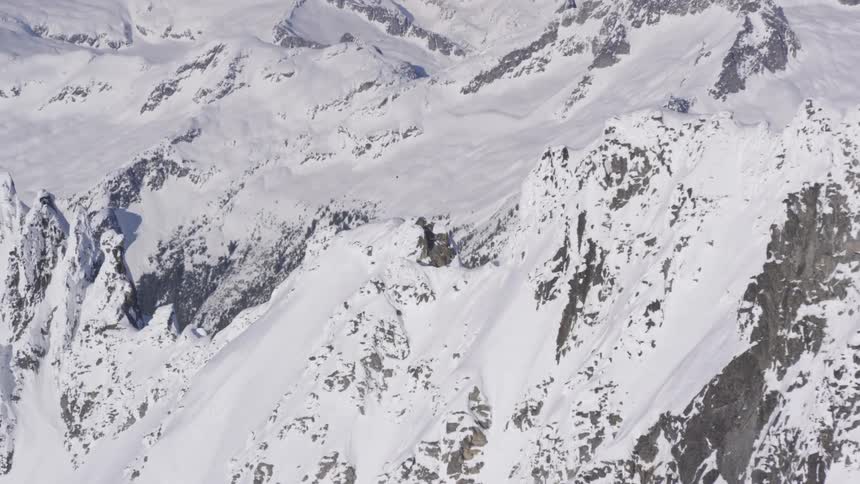 Aerial over snowy tops on a mountain range