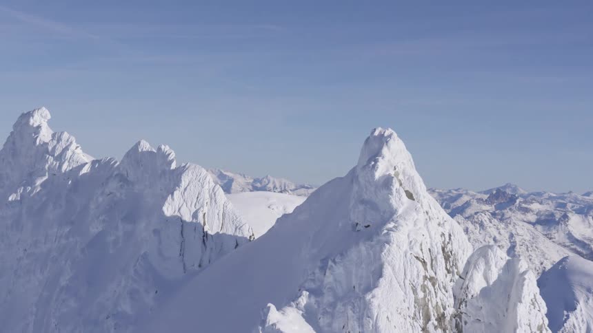 Snow covered mountain peaks under a clear blue sky