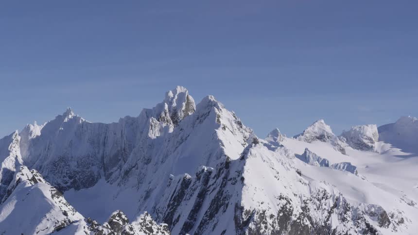 Snowcovered mountains with sharp peaks under a clear blue sky