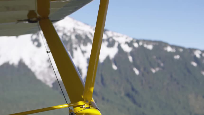 Yellow aircraft structure with a snowcapped mountain in the background