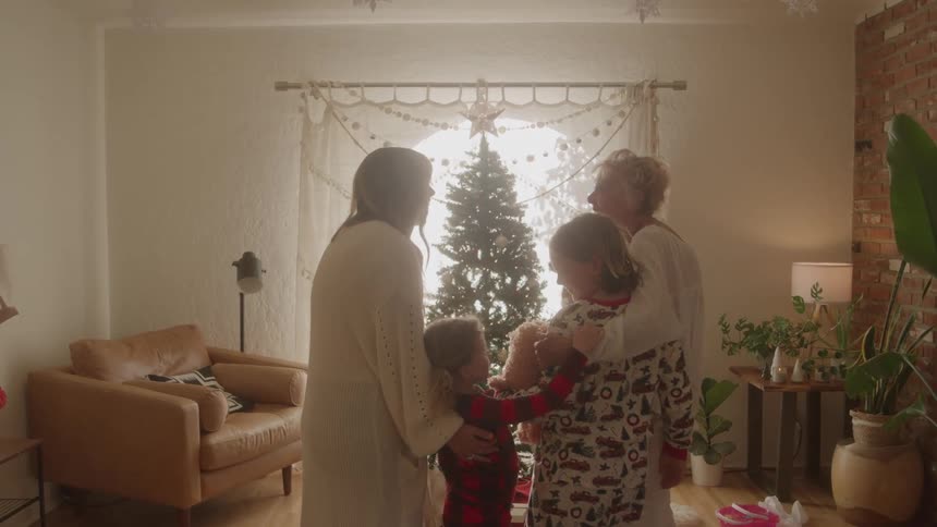 Family gathered in front of the decorated christmas tree
