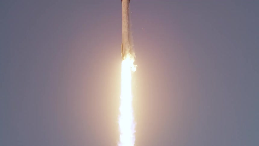 Rocket Launches and ascends into the Clear Blue Sky its Engines Emitting a Bright Plume of Exhaust