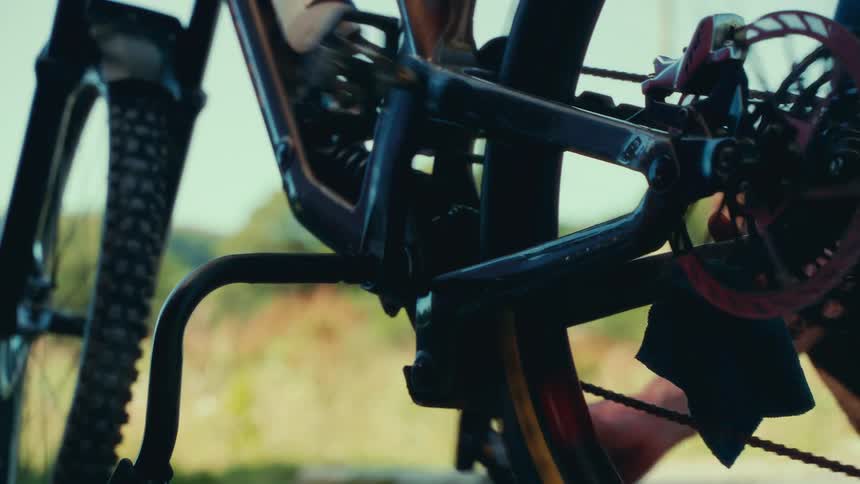 The video shows a closeup shot of the lower frame and rear wheel of a bicycle a person is seen working on the bike and the video has a watermark that reads filmsupply