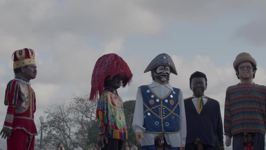 Giant puppets dressed in colorful outfits at an outdoor event