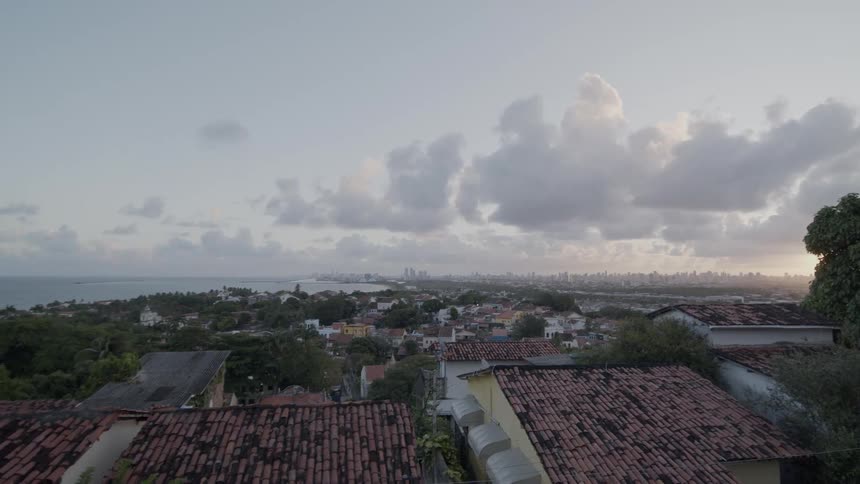 Panoramic view of a coastal city at sunrise with clouds over the clear sky