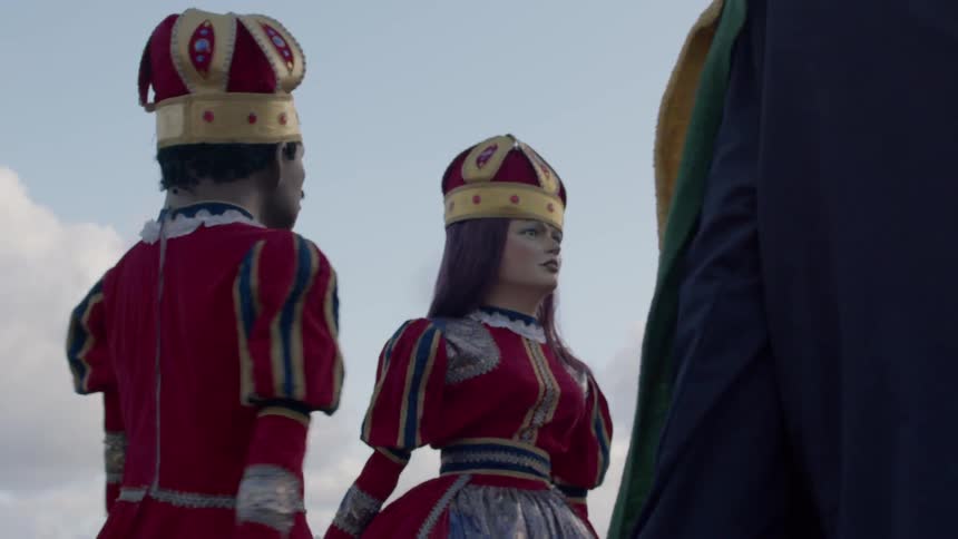 Giant puppets dressed in colorful clothes during an outdoor event