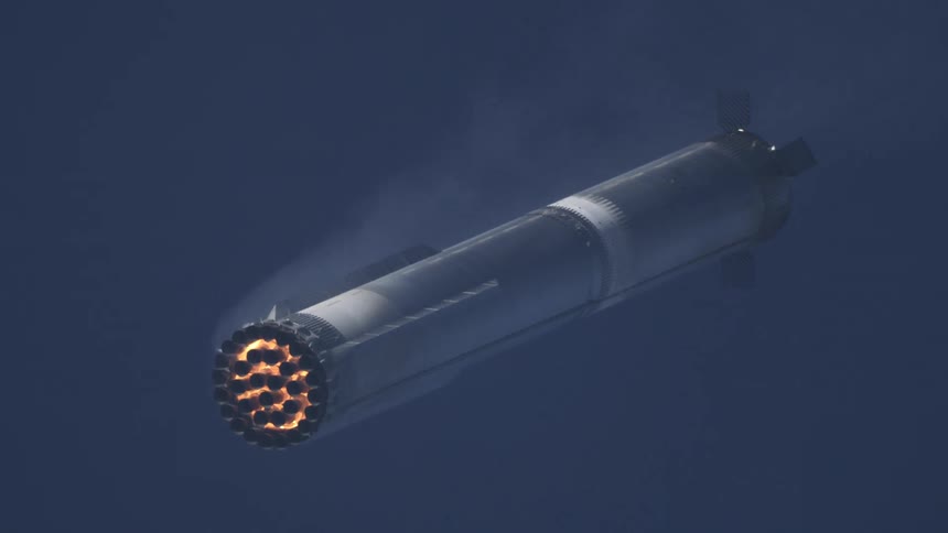 Rocket booster fires mid flight against dark sky