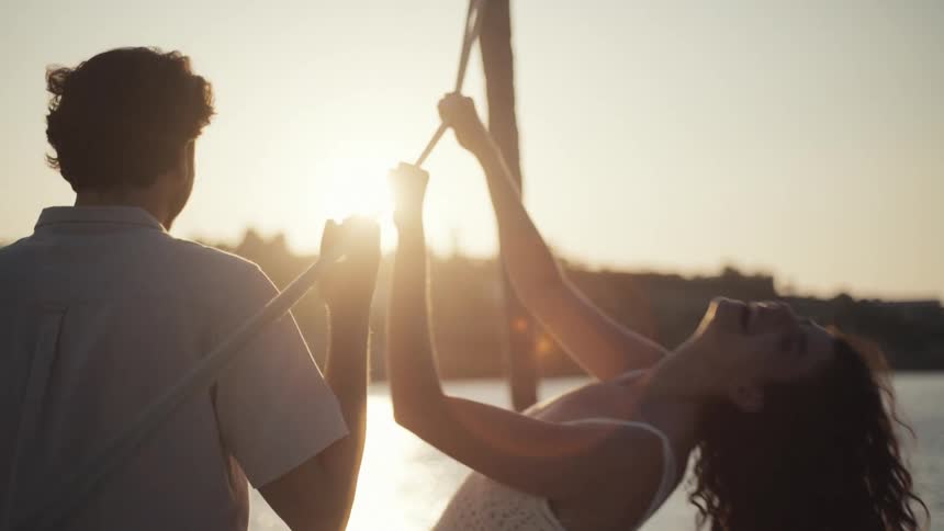 A romantic couple shares an intimate moment by the water during sunset