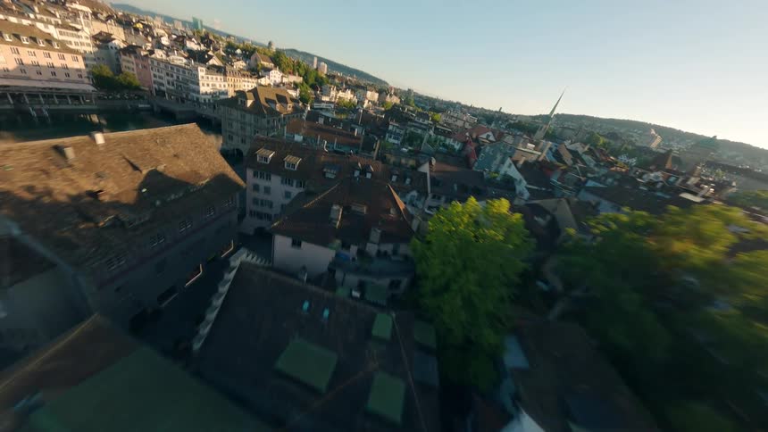 FPV drone flies over a big city at sunrise