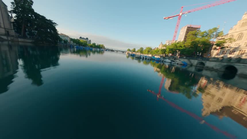 Multiple churches and apartment buildings border a channel lined with docks near a construction site in a coastal town