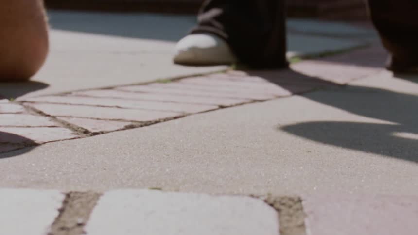 A persons hands shows them reaching down to pick up a pair of eyeglasses from the ground