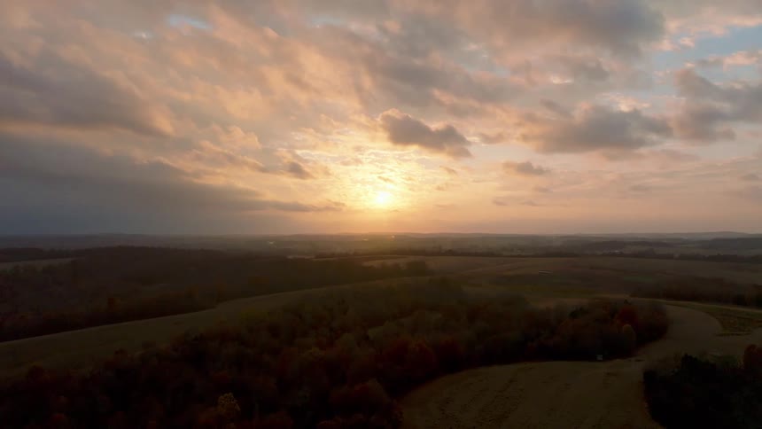 Aerial view of sunset over rolling hills and fields