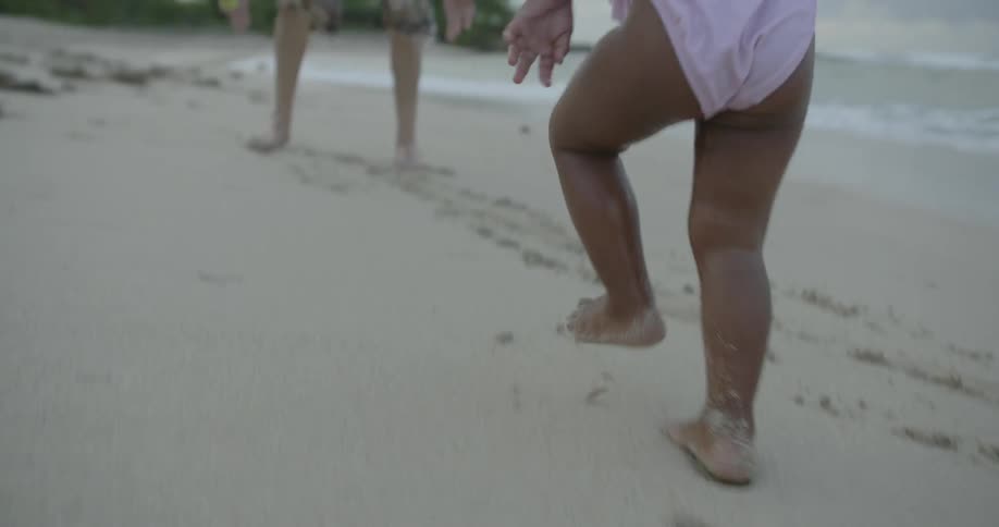 A young baby runs on the beach