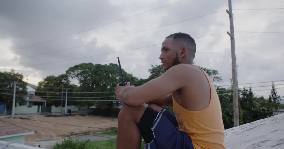 A man is holding a walkie talkie outside