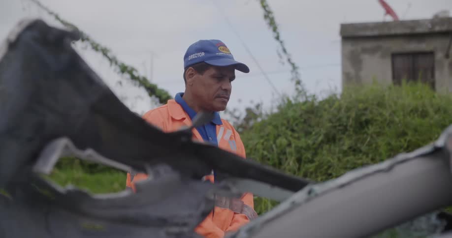 Man looking at some wreckage outdoors