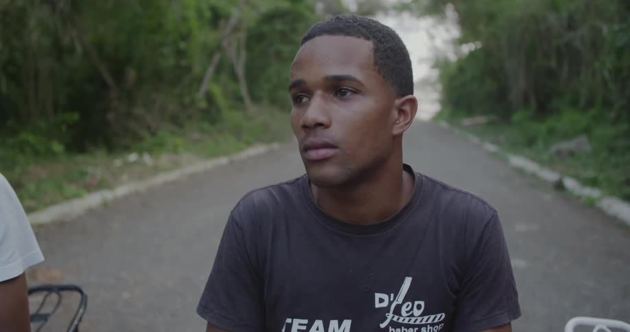 Young man sitting solemnly in the middle of a barren road