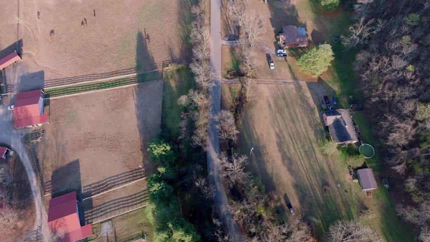 Rural road divides fields and houses with large yards seen from above