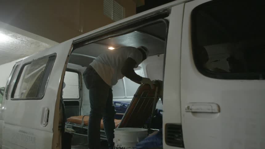 A paramedic wipes down the inside of his van