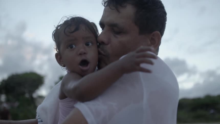Man holding and kissing toddler girl on the cheek
