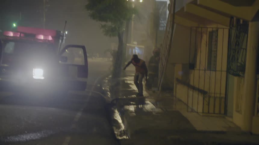 Firefighters adjust hoses in an urban setting