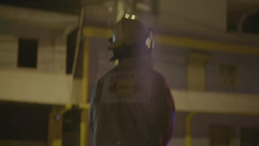 A rescue worker walks away from a truck while lights flash