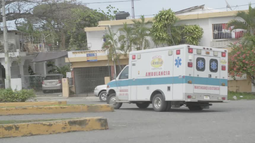 An ambulance drives near buildings
