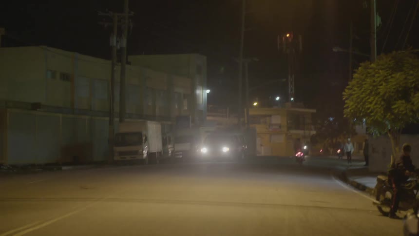 An ambulance drives on a city street at night