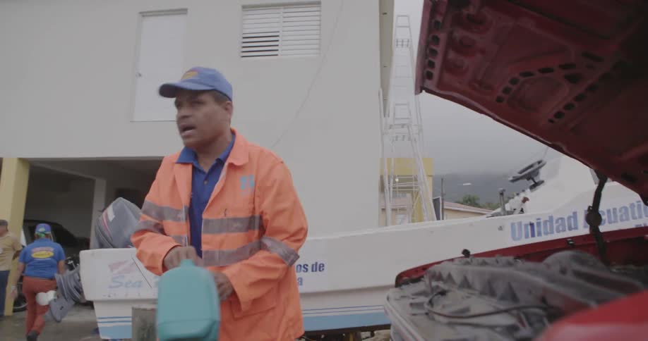 Man closing the hood of a pick-up truck after adding fluids