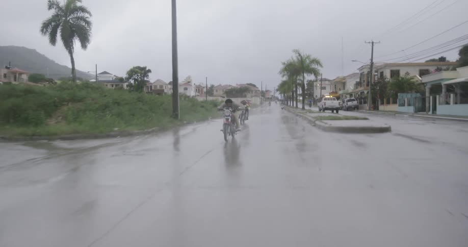 Motorcycles travel down the road in the rain