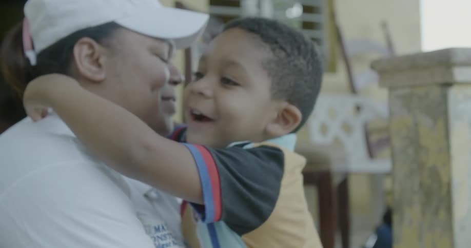 A woman and young boy hug and kiss