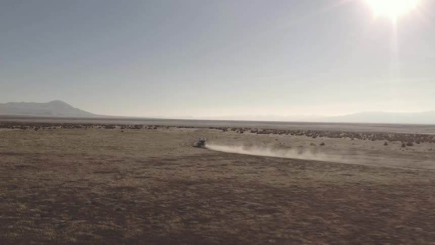 Aerial vehicle driving across large open land in the desert