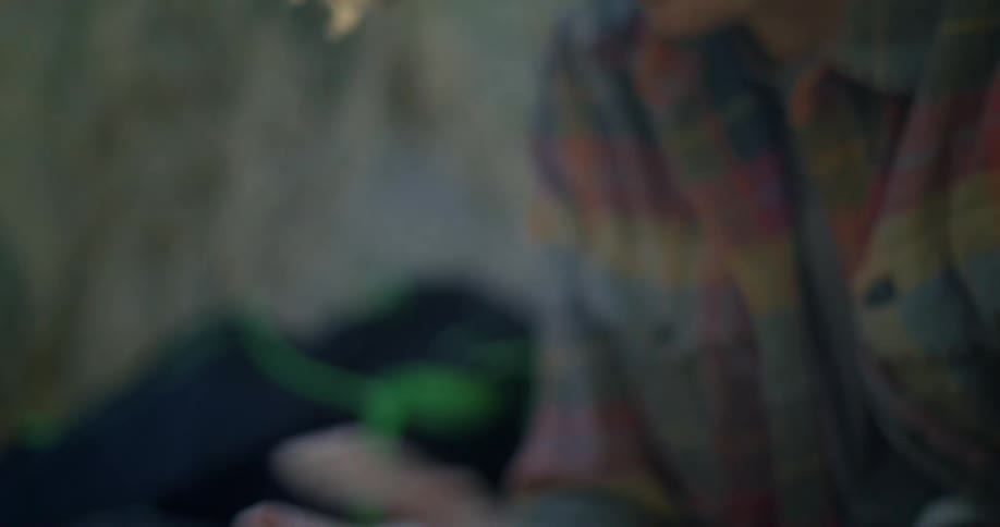 A man in a plaid shirt rubs his hands together then blows gently into his chalkcovered hands