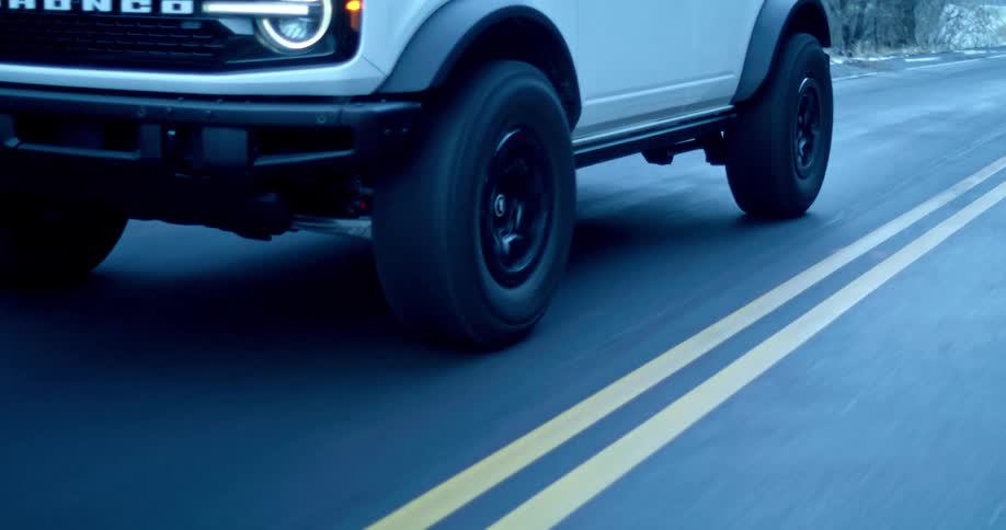 An suv drives on an icy road in winter at midday