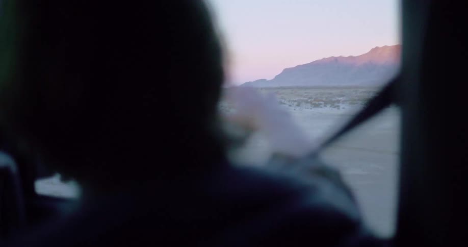 Man with his arm out of a moving car