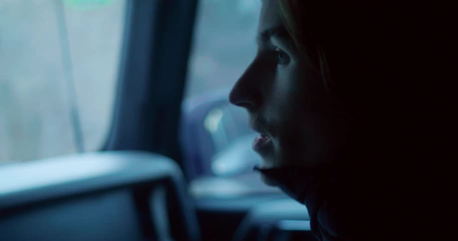 Man looks out the window of a moving car