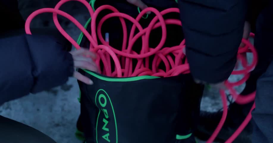 Two people organize climbing ropes for travel