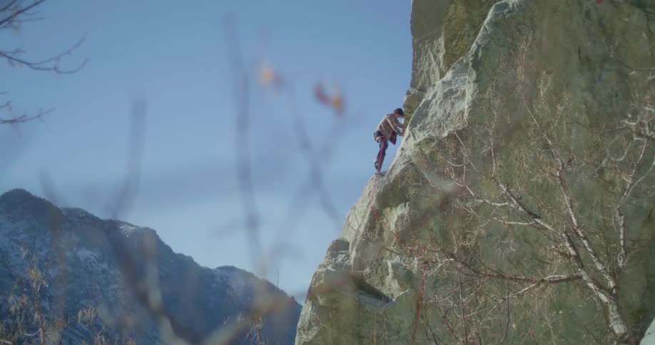 A person climbs a steep rock face on a mountain