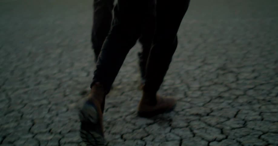 Couple holds hands and dances outdoors during sunset