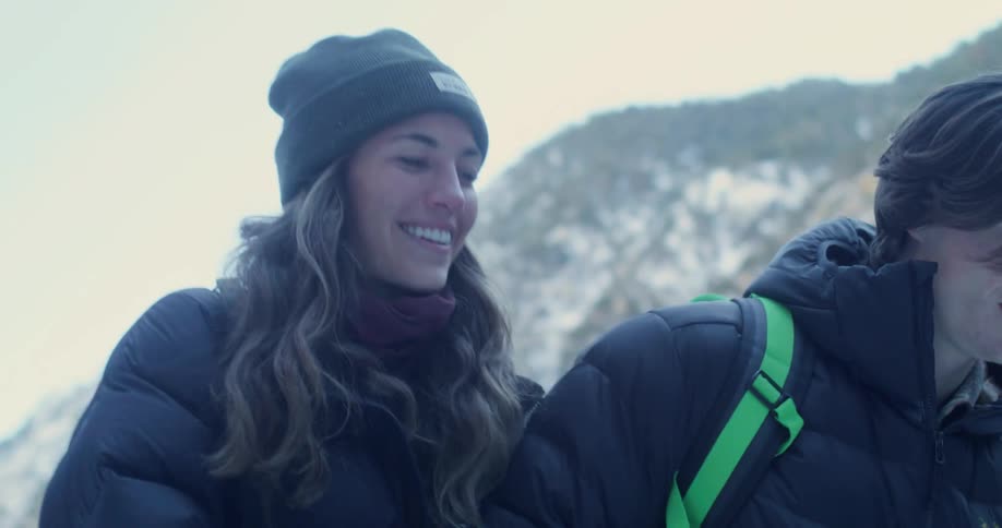Two young people dressed for the cold walk smiling in a snowy area