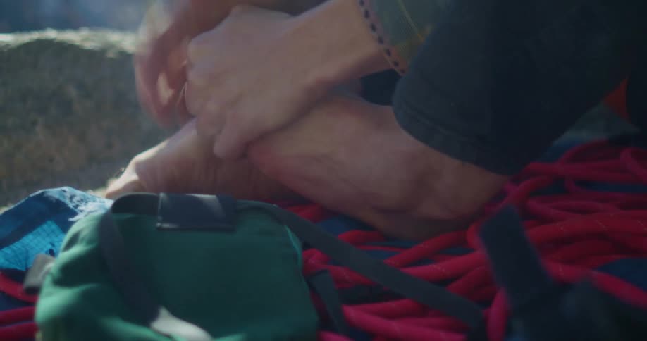 Hand resting on a bare foot during an outdoor break