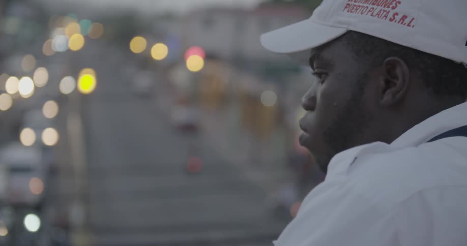 A man stands overlooking a busy city street