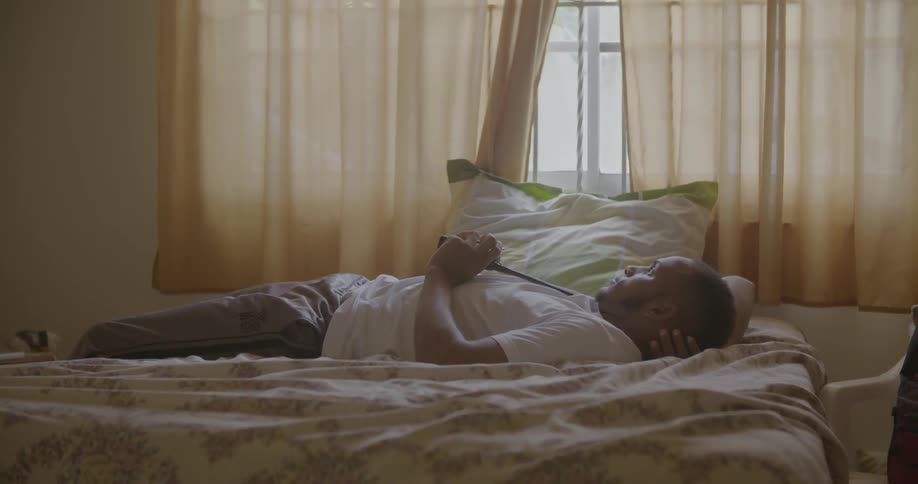 A man lays in bed with a walkie talkie