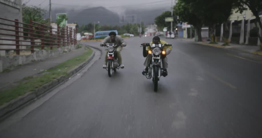 People are riding down the windy road on motorcycles
