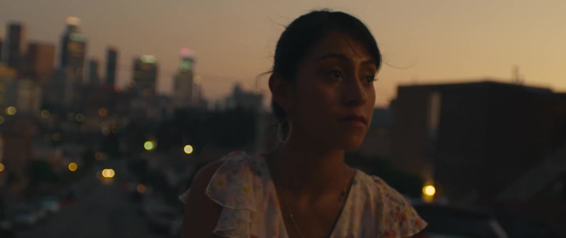 Two young people in the foreground with blurred city lights in the background