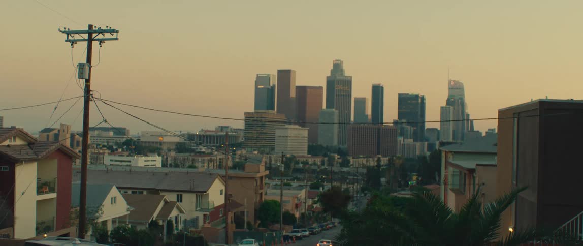 The road in town leads to the tall buildings